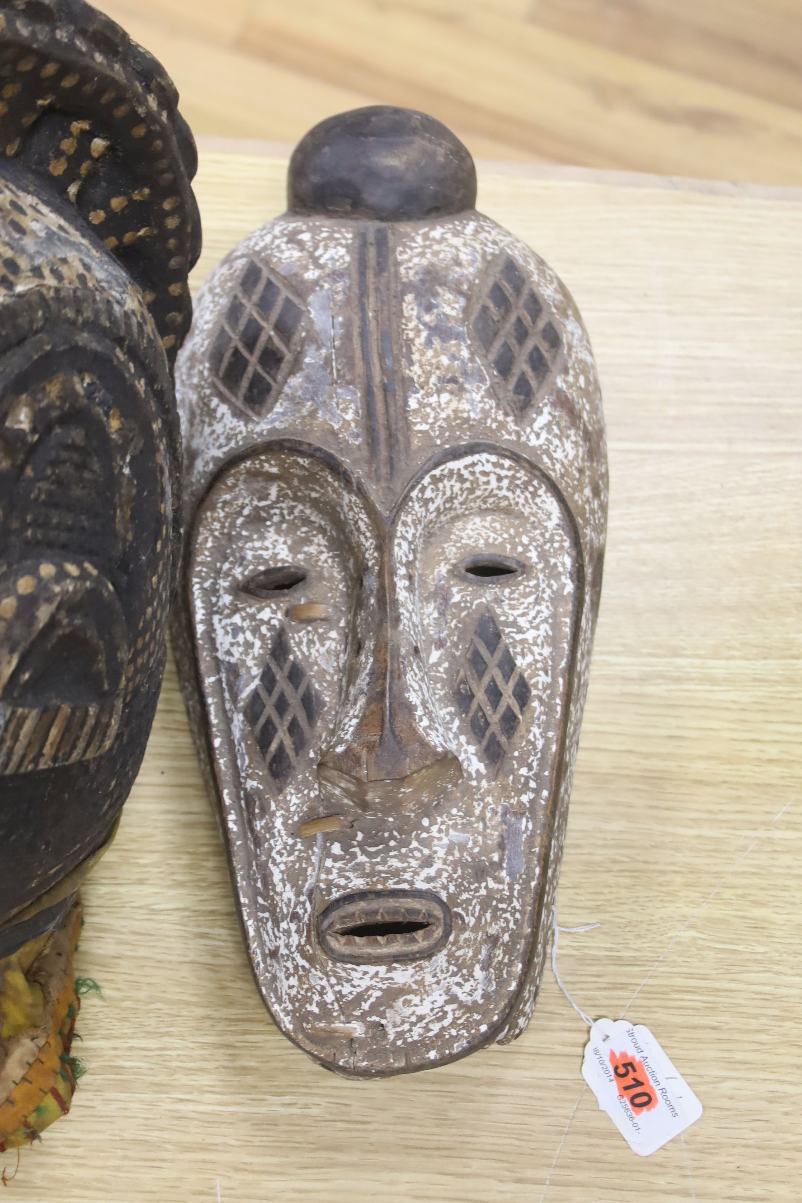 An African helmet mask, possibly Kaba, and two others